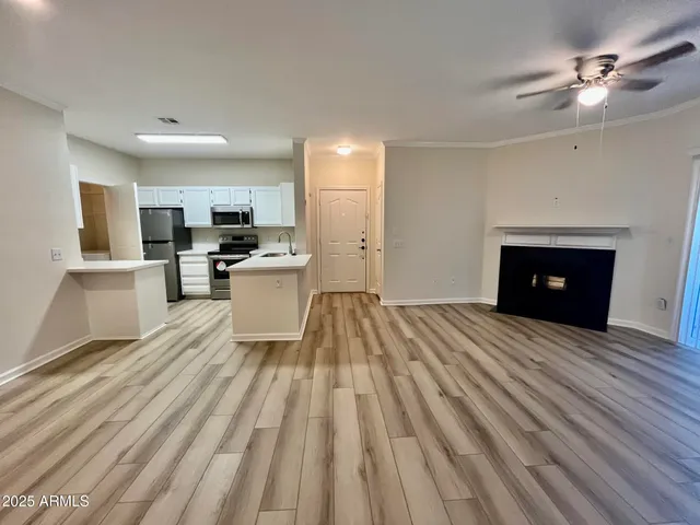 a view of a kitchen with wooden floor and a fireplace