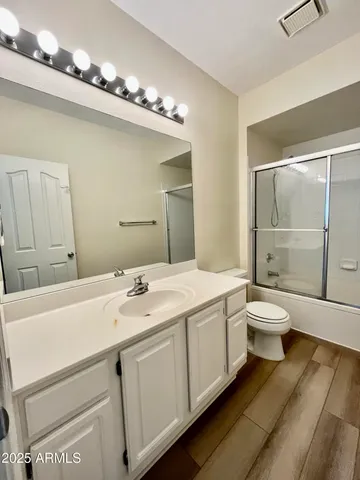 a bathroom with a granite countertop sink a toilet and a mirror