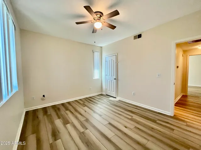 a view of an empty room with wooden floor