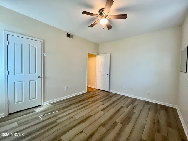 a view of empty room with wooden floor