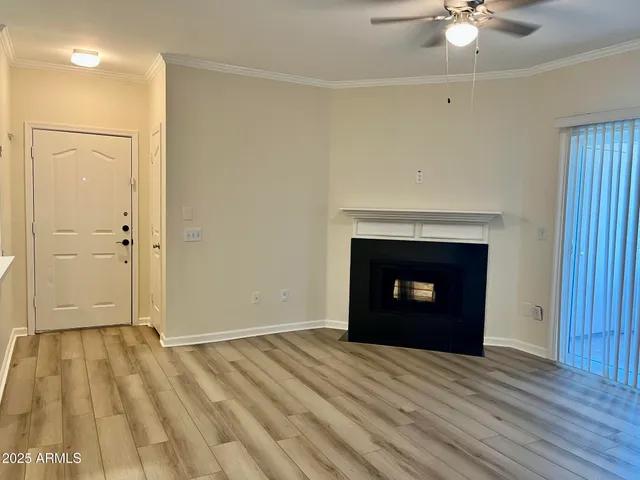 a view of empty room with wooden floor and fireplace