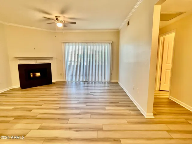 a view of a livingroom with wooden floor and a fireplace