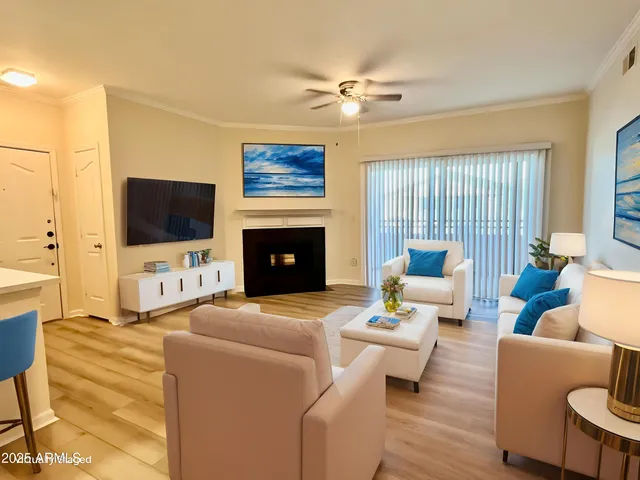 a living room with furniture a flat screen tv and a fireplace