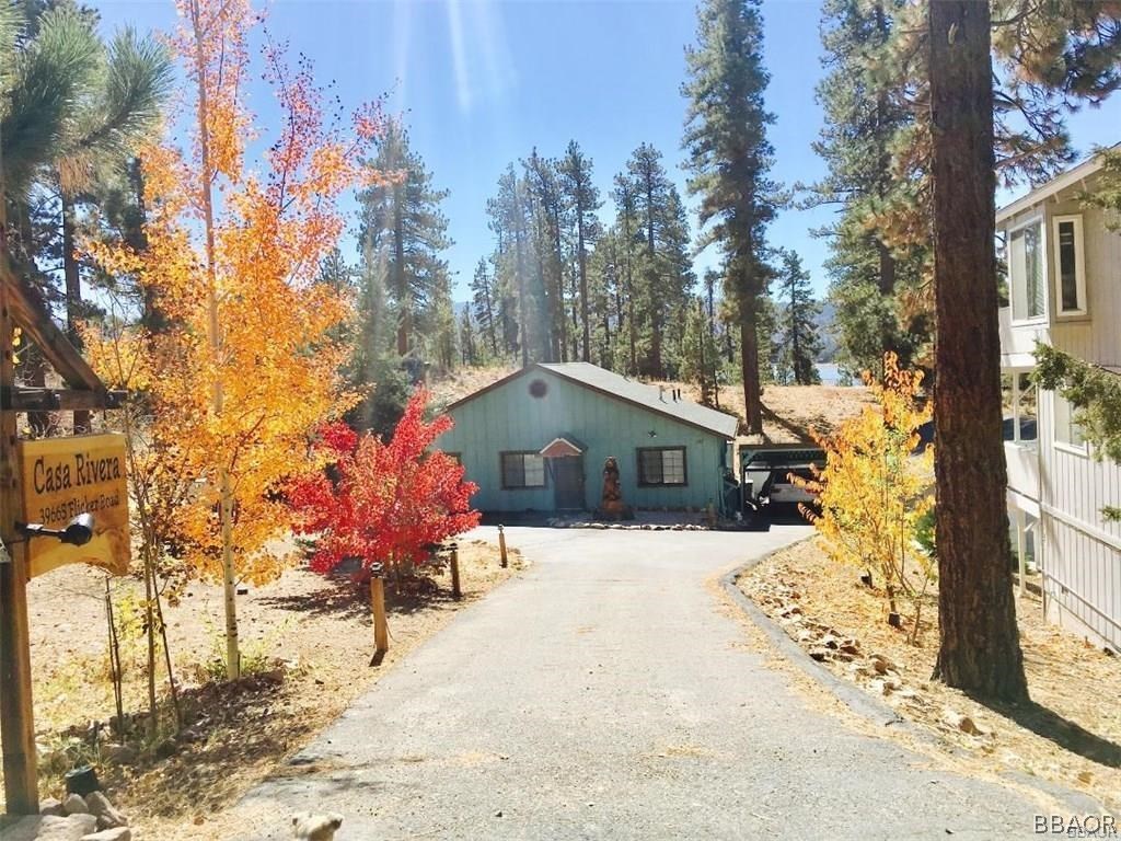 a front view of a house with a yard covered with snow