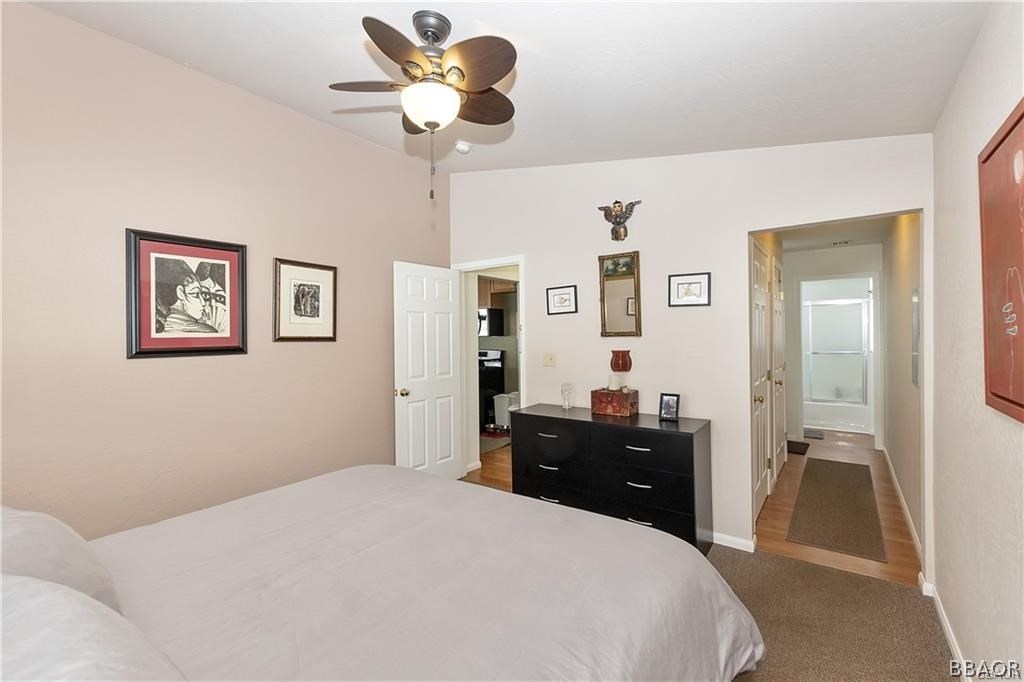 39665 Flicker Road Fawnskin, CA 92333 - Photo 14 of 29 a bedroom with a bed and a chandelier