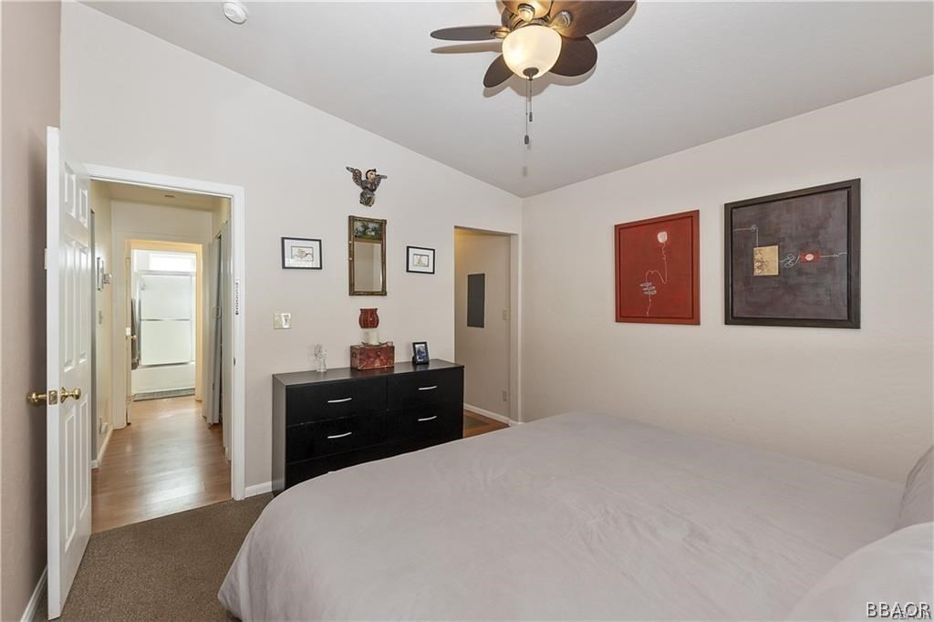 39665 Flicker Road Fawnskin, CA 92333 - Photo 15 of 29 a bedroom with a bed and a chandelier