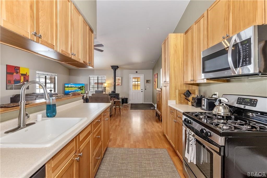39665 Flicker Road Fawnskin, CA 92333 - Photo 10 of 29 a kitchen with stainless steel appliances granite countertop a stove a sink and a microwave