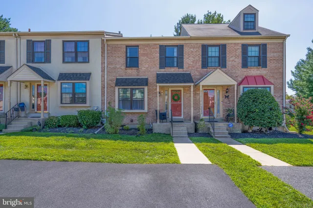 a view of a brick house with a yard and plants