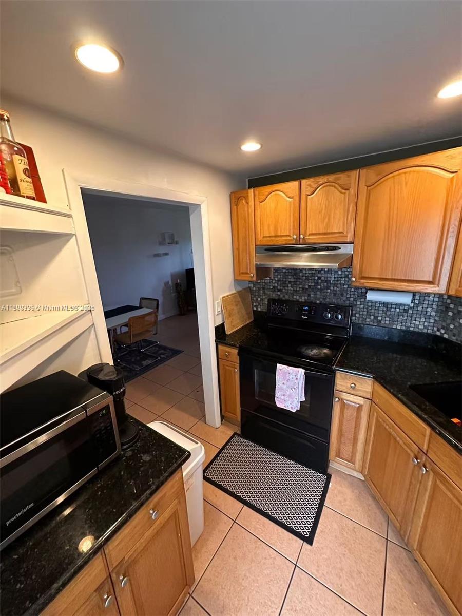 1021 Crystal Lake Drive, Unit 311 Deerfield Beach, FL 33064 - Photo 6 of 17 a kitchen with granite countertop a stove and a refrigerator