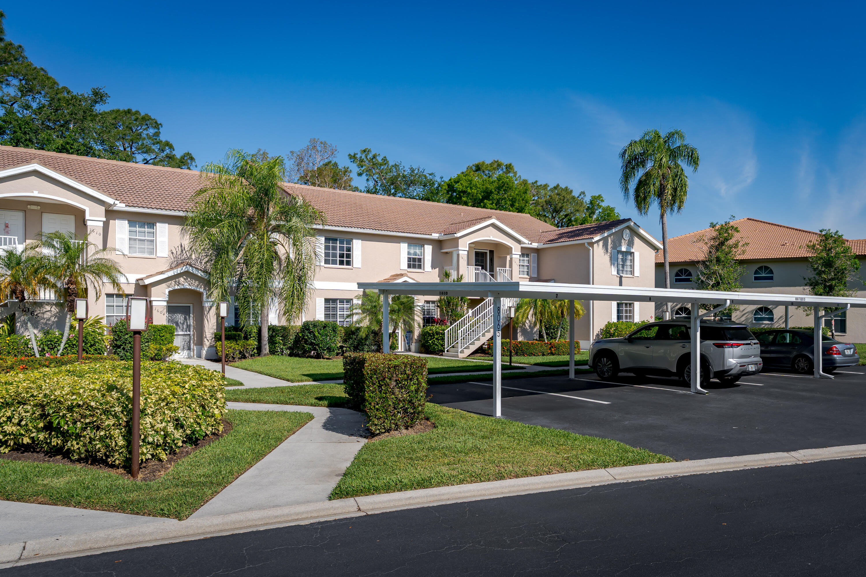 8065 Tiger Cove, Unit 1611 Naples, FL 34113 - Photo 4 of 40 Front of condo, view of parking and fr