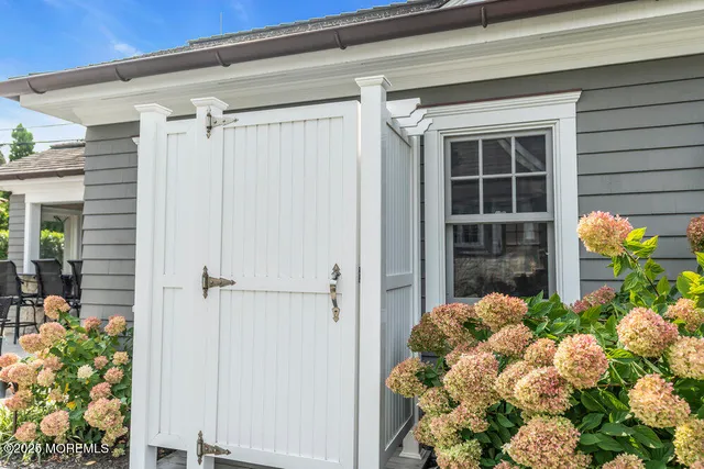 a view of a patio with table and chairs potted plants and floor to ceiling window