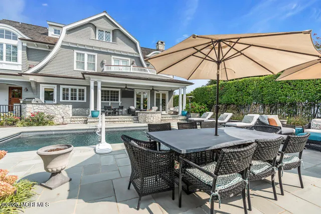 a view of a patio with table and chairs potted plants with wooden floor and fence