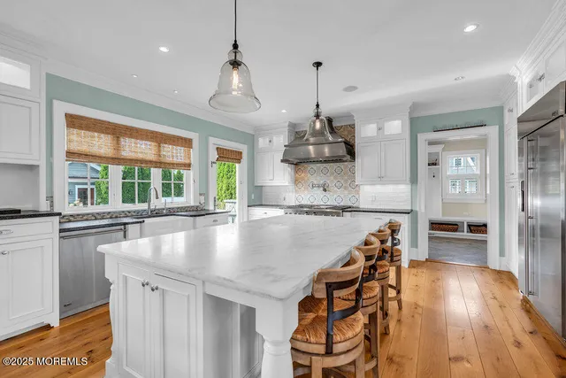 a living room with furniture kitchen view and a large window