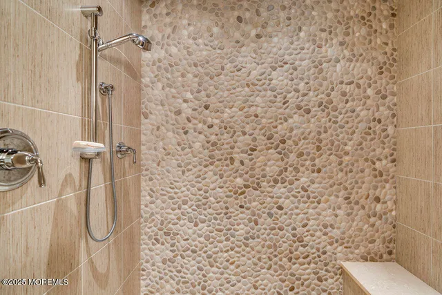 a bathroom with a sink a toilet a mirror and shower