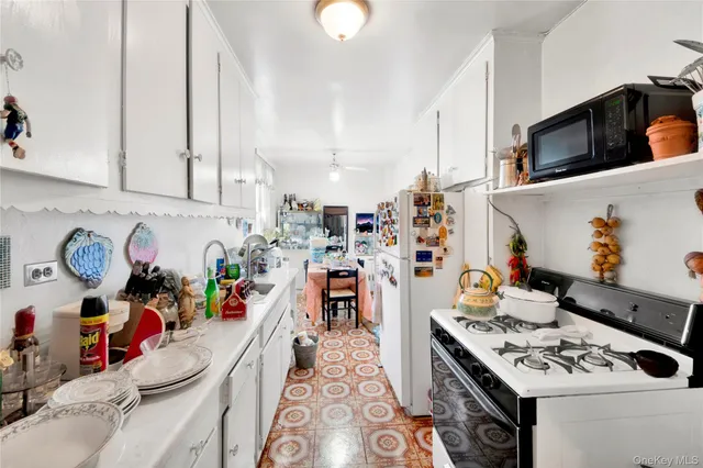 a kitchen with a white stove top oven and cabinets