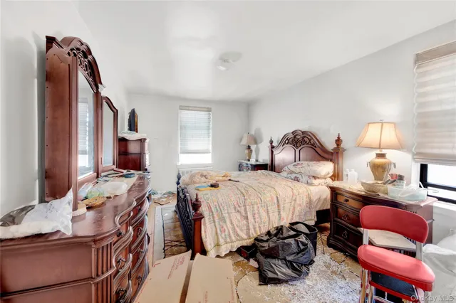 a bedroom with bed and a large window