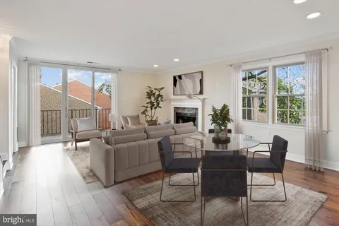 a living room with furniture fireplace and a large window