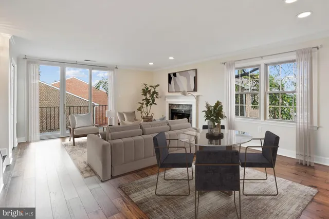 a living room with furniture fireplace and a large window