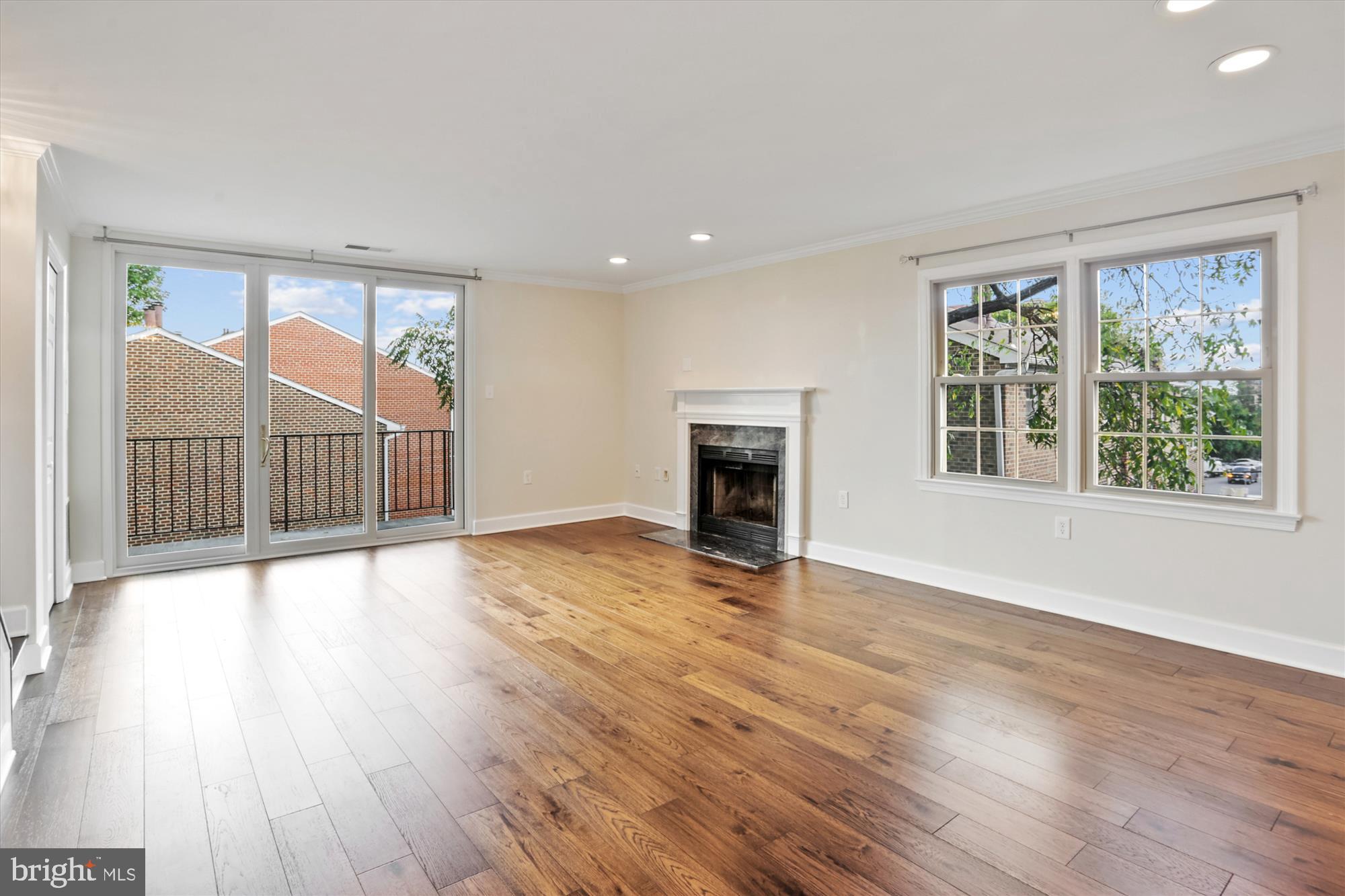 945 South Scott Street Arlington, VA 22204 - Photo 2 of 39 an empty room with wooden floor fireplace and windows