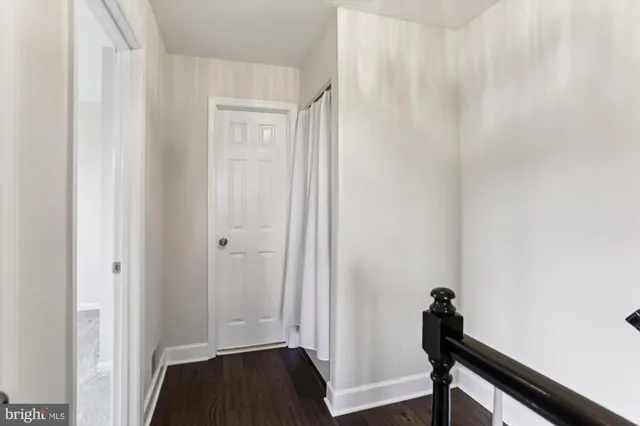 a view of a room with wooden floor and front door