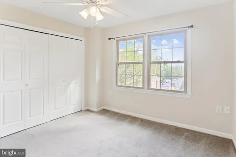 an empty room with windows and closet