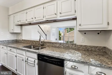 a kitchen with granite countertop a sink and cabinets
