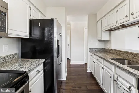 a kitchen with stainless steel appliances granite countertop a refrigerator and a stove