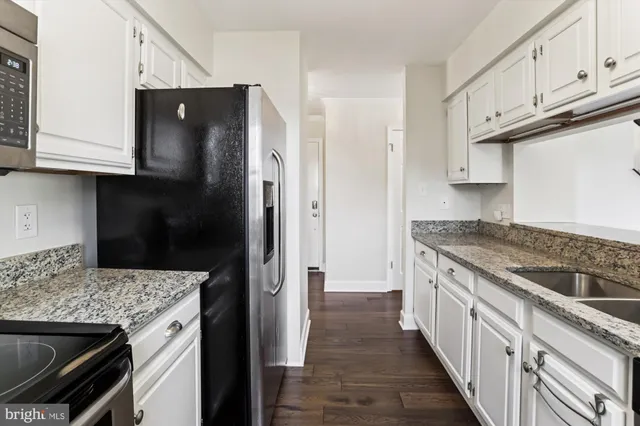 a kitchen with stainless steel appliances granite countertop a refrigerator and a stove
