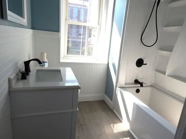 a bathroom with a sink a window and a shower