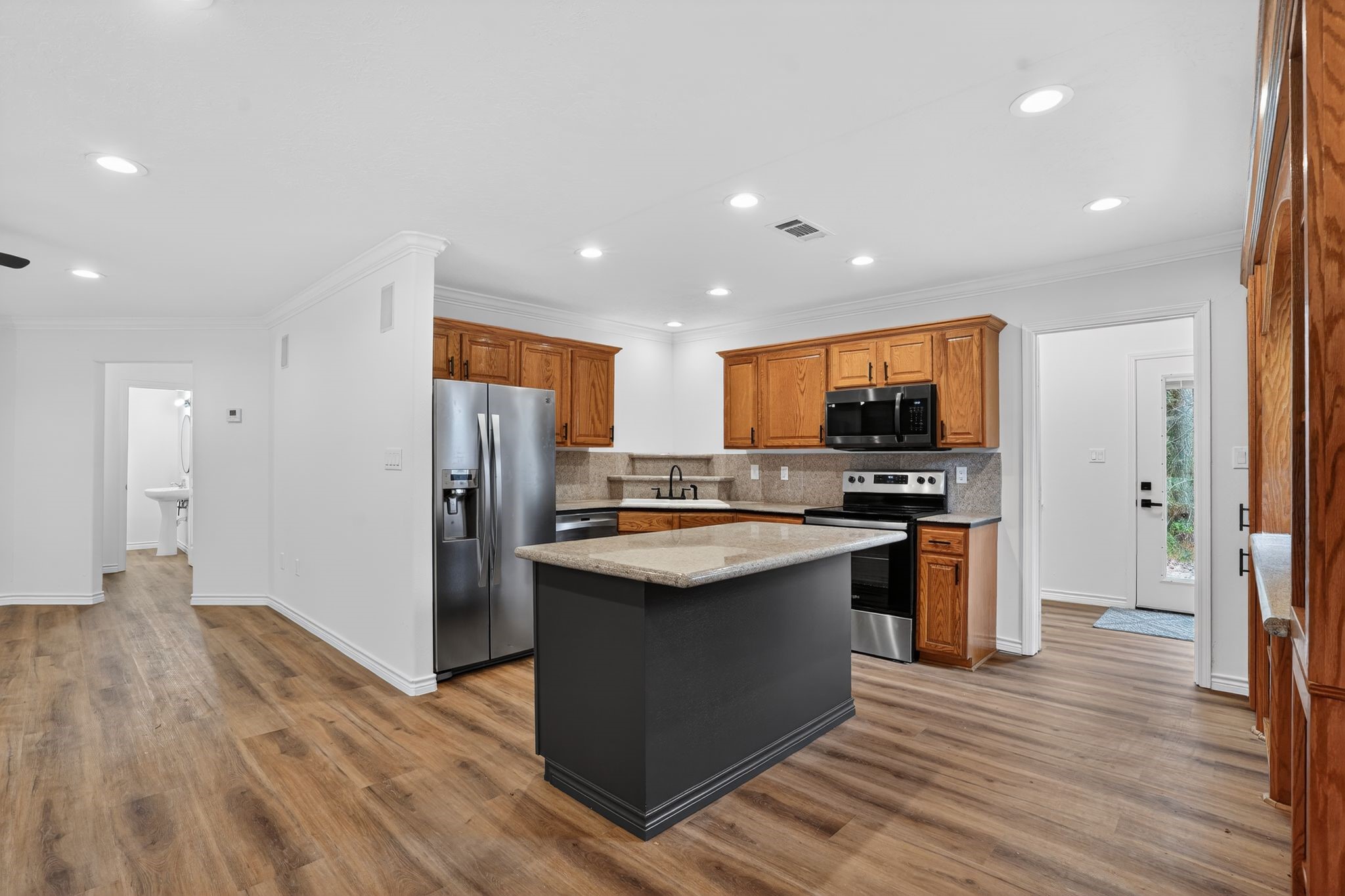 27 Deerfield Road Huntsville, TX 77340 - Photo 39 of 46 a kitchen with stainless steel appliances granite countertop a refrigerator and a stove top oven