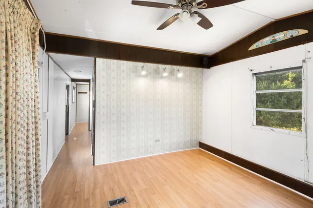 a view of a big room with wooden floor and windows