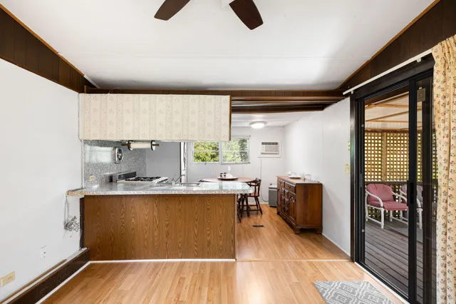 a kitchen with wooden cabinets a sink a stove and a window