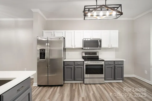 a kitchen with stainless steel appliances granite countertop a refrigerator a stove a sink and dishwasher