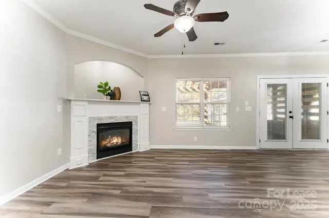 a view of an empty room with a window and fireplace