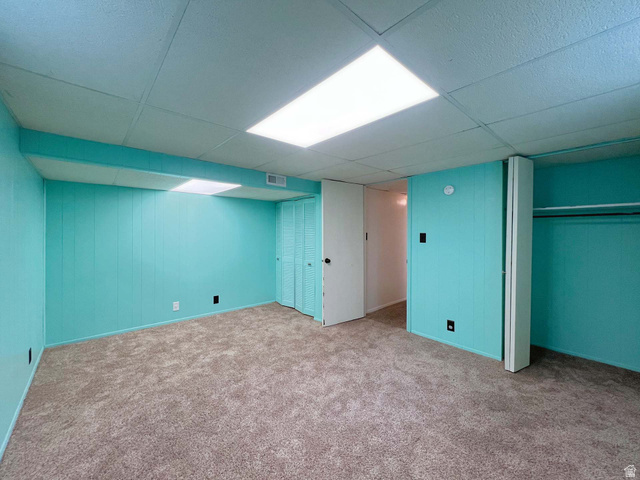 3138 Jean Street Magna, UT 84044 - Photo 25 of 26 Carpeted room featuring teal vertical paneling, white ceiling tiles with integrated lighting, and a white interior door