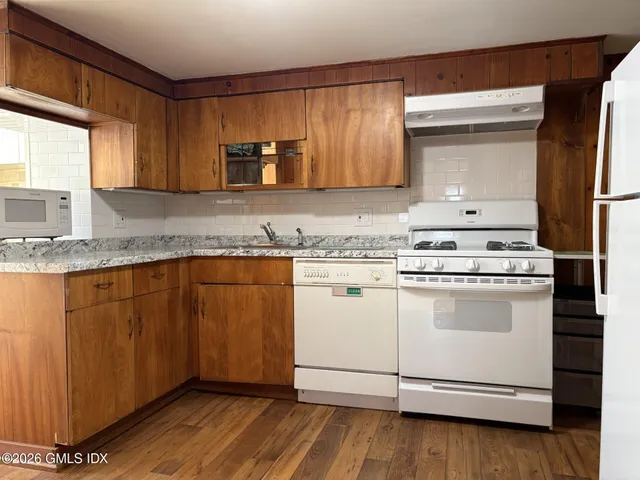 a kitchen with granite countertop wooden cabinets stainless steel appliances and a window