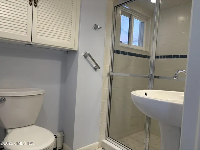 a bathroom with a toilet a sink and a window