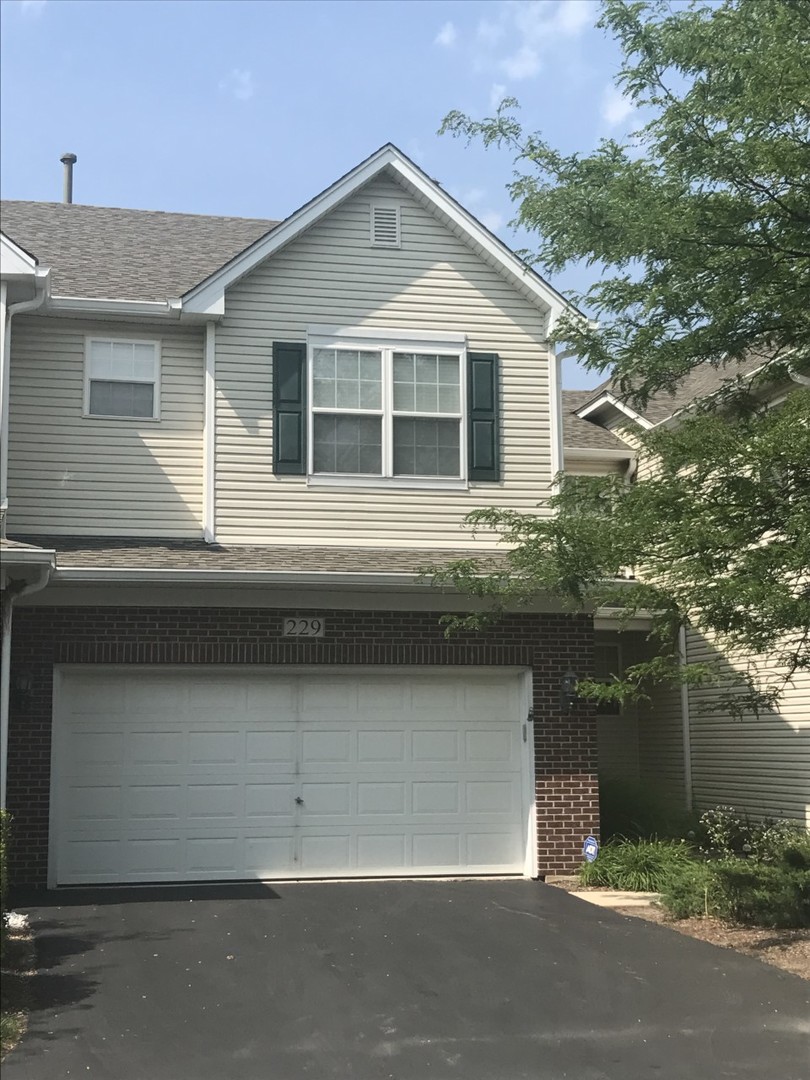 229 Ridge Road North Aurora, IL 60542 - Photo 1 of 18 a front view of a house with garage