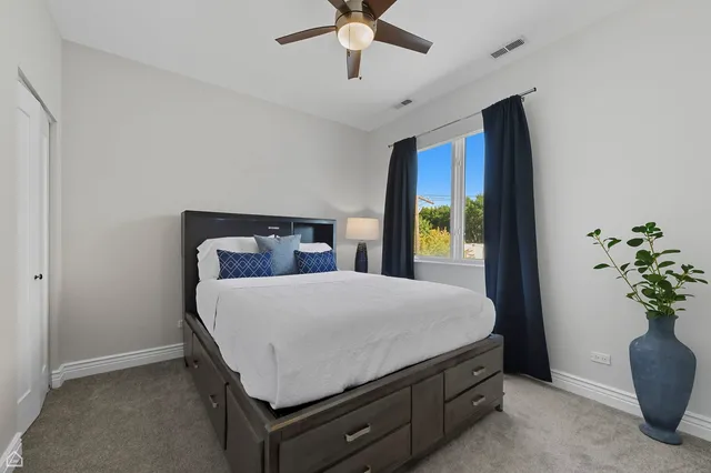 a bedroom with a bed and a potted plant