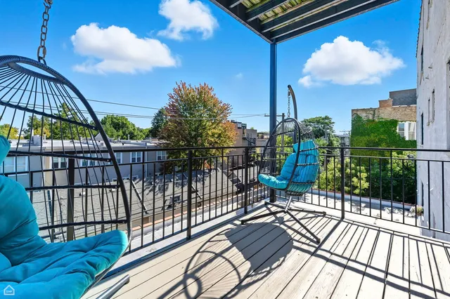 a view of a balcony with wooden floor and iron fence