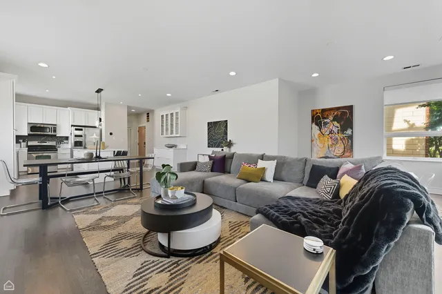 a living room with furniture and view of kitchen