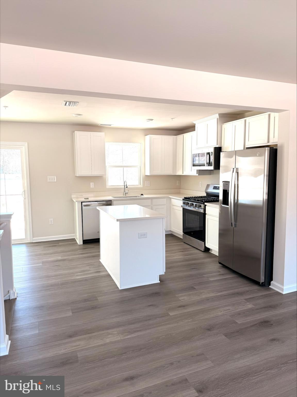 1180 West Walnut Road Vineland, NJ 08360 - Photo 4 of 19 a kitchen with a center island wooden floor and stainless steel appliances