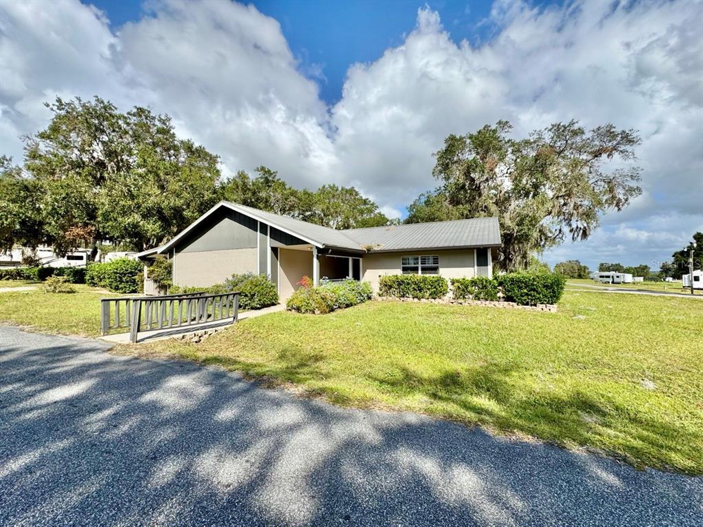 15991 Northeast 243rd Place Road, Unit 56 Fort McCoy, FL 32134 - Photo 7 of 16 a view of a house with a big yard and large trees