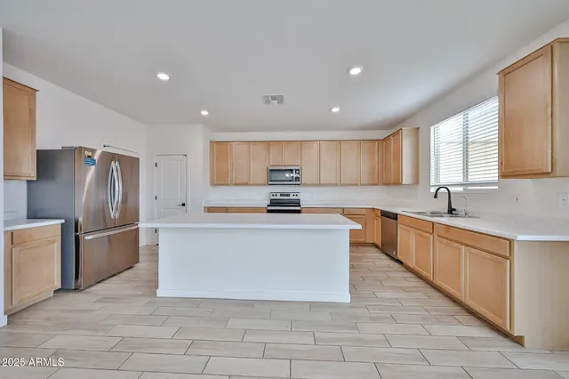 a large kitchen with stainless steel appliances lots of white cabinets