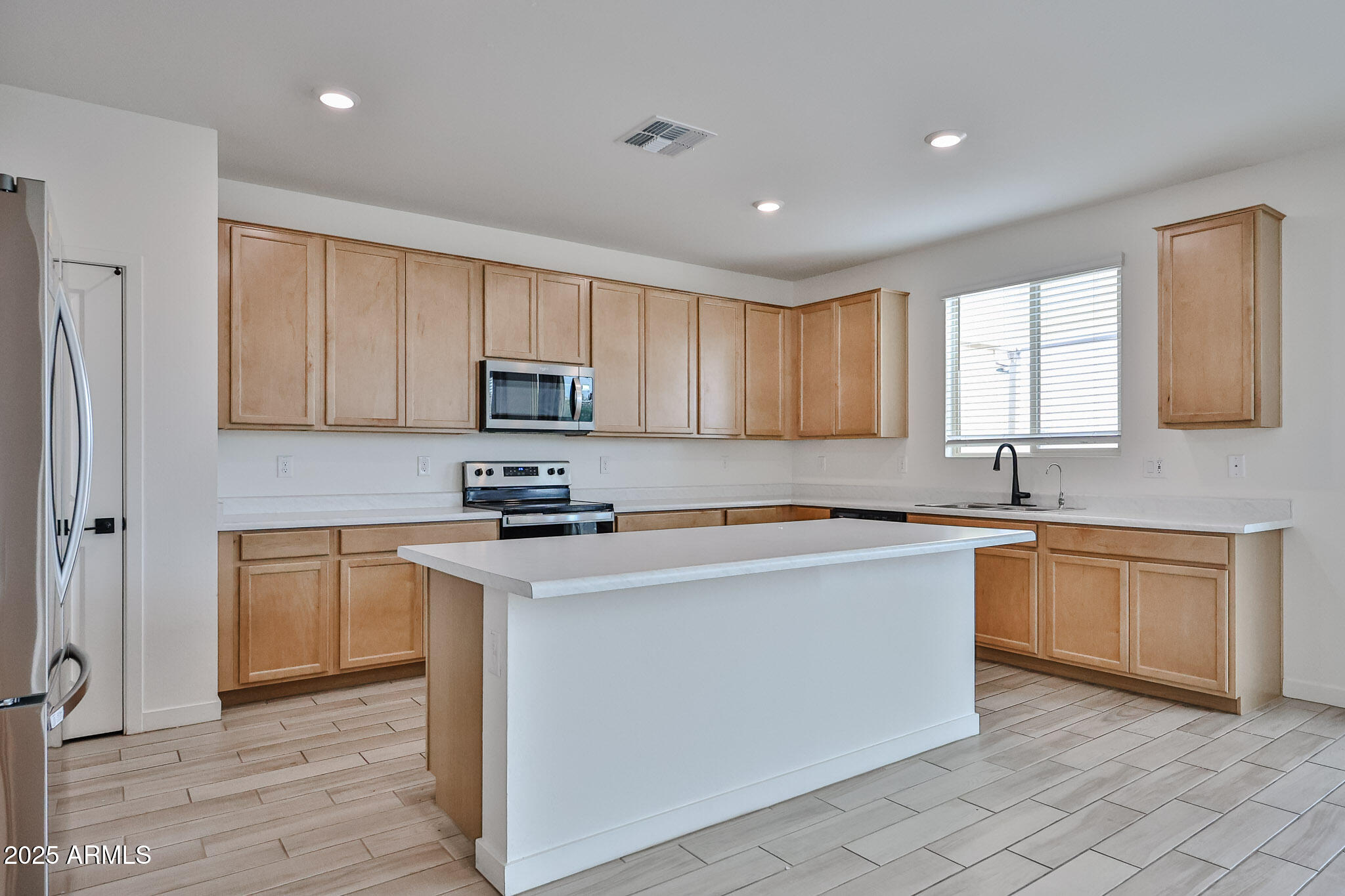 509 East Elm Lane Avondale, AZ 85323 - Photo 12 of 40 a kitchen with stainless steel appliances granite countertop a stove top oven a sink and dishwasher a refrigerator with wooden floors