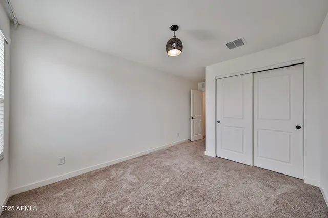 a view of an empty room and a ceiling fan