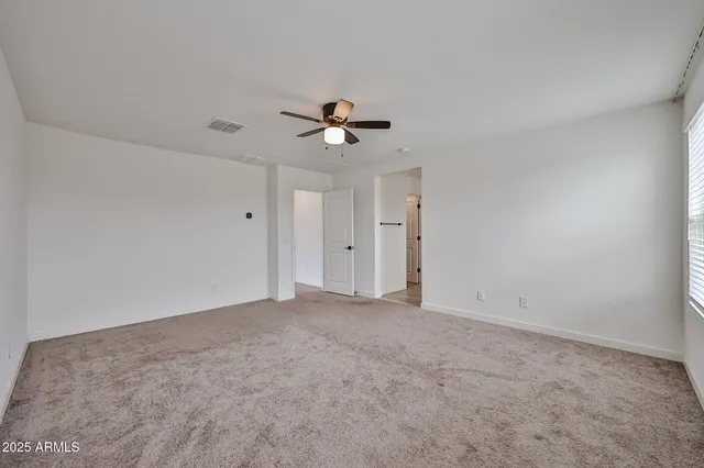 a view of an empty room with a ceiling fan