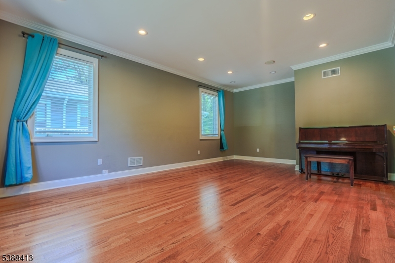 567 Mountain Avenue Springfield, NJ 07081 - Photo 3 of 28 a view of empty room with wooden floor and fan