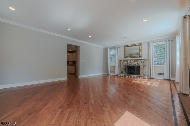 567 Mountain Avenue Springfield, NJ 07081 - Photo 8 of 28 an empty room with wooden floor and fireplace
