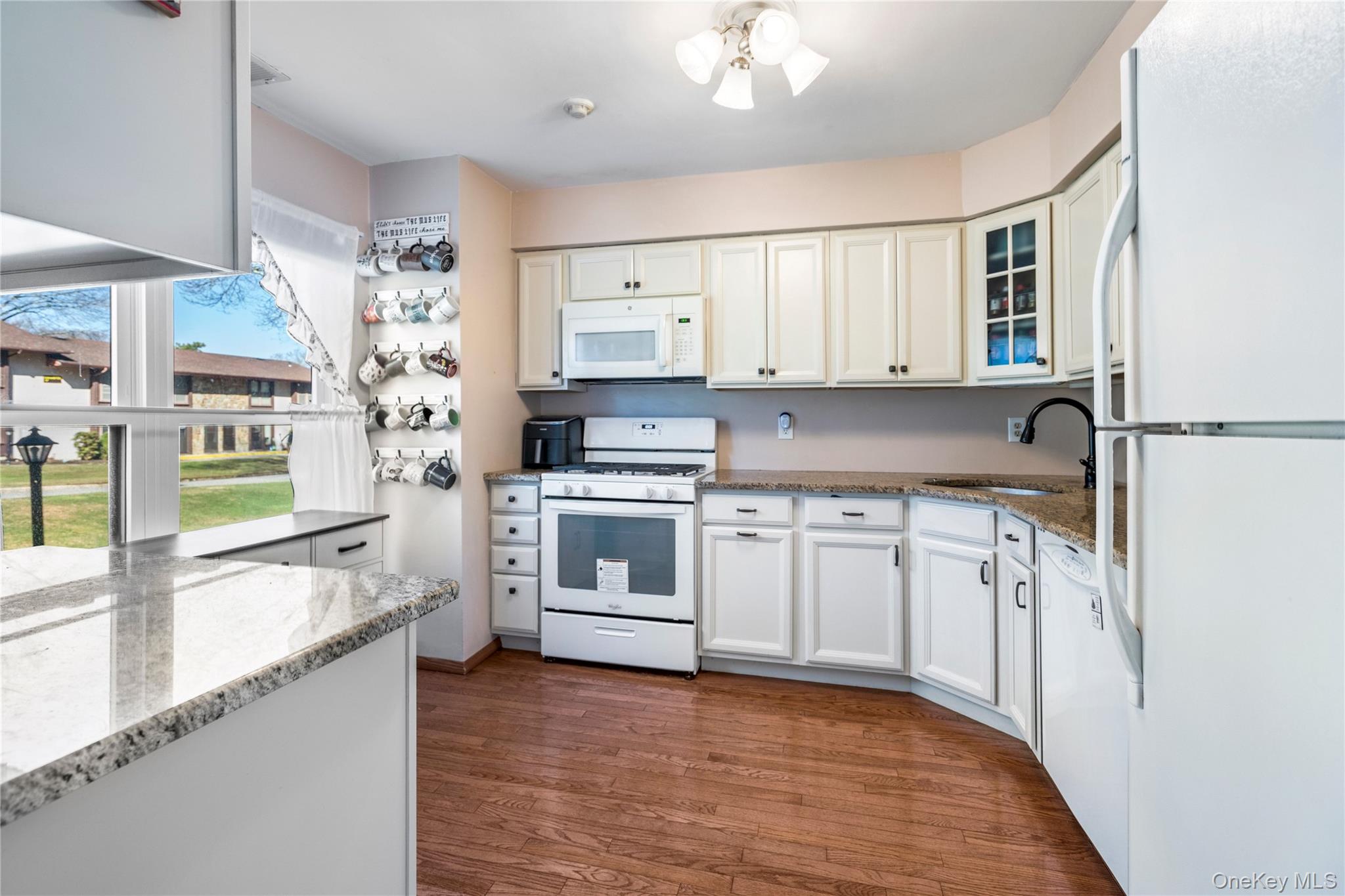 7 Maple Court, Unit 7 Selden, NY 11784 - Photo 5 of 18 a kitchen with granite countertop a sink cabinets stainless steel appliances and a window
